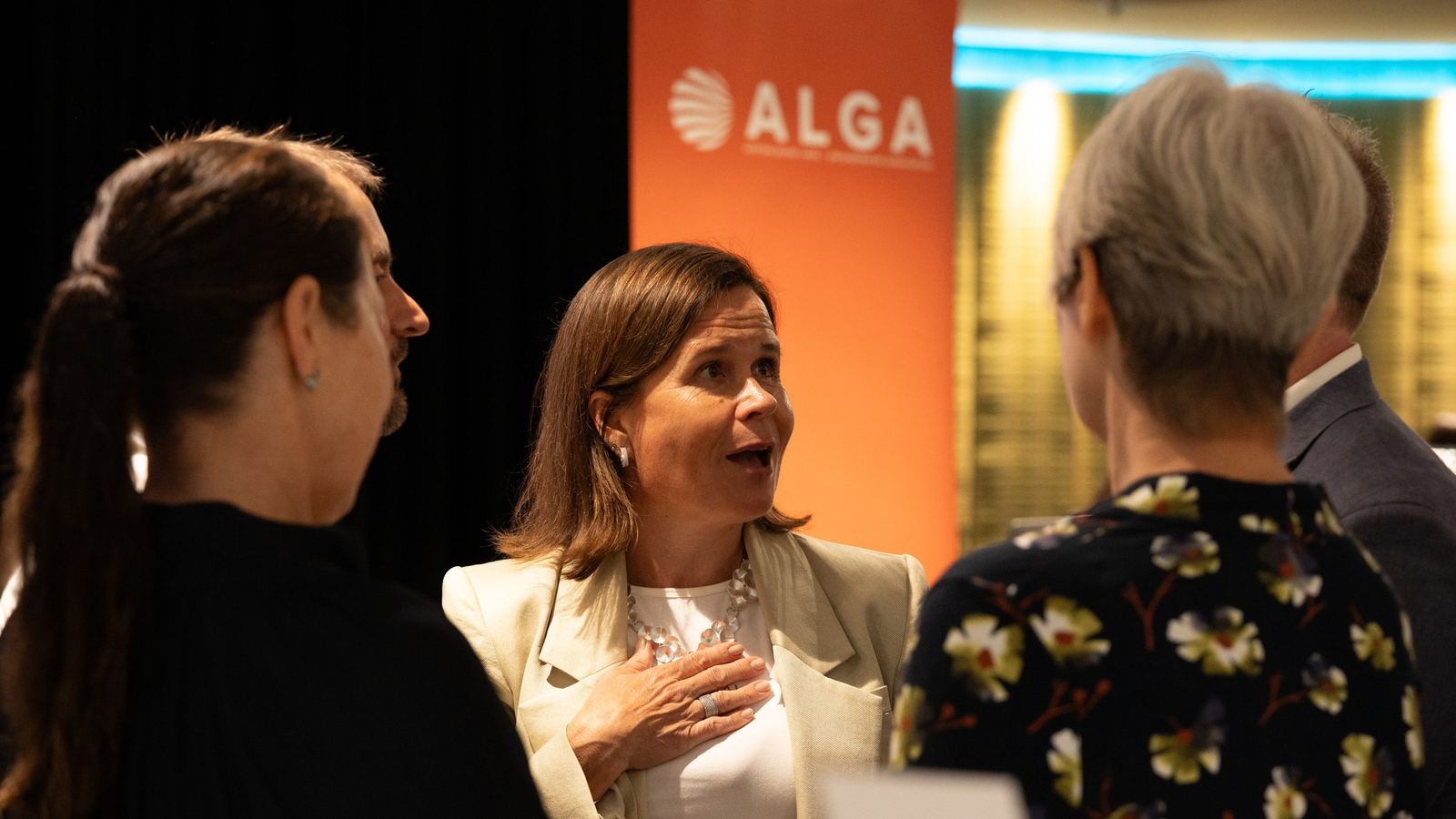 Guests talking beside the event banner