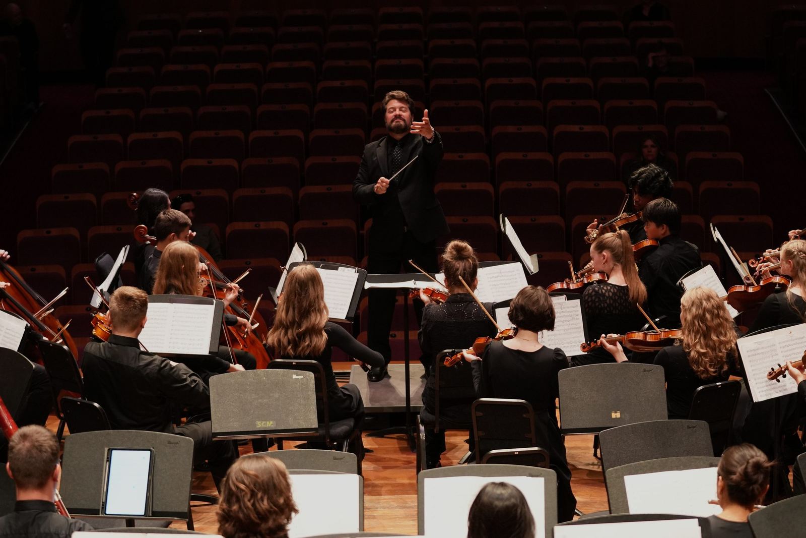 Conductor reaching toward the violins