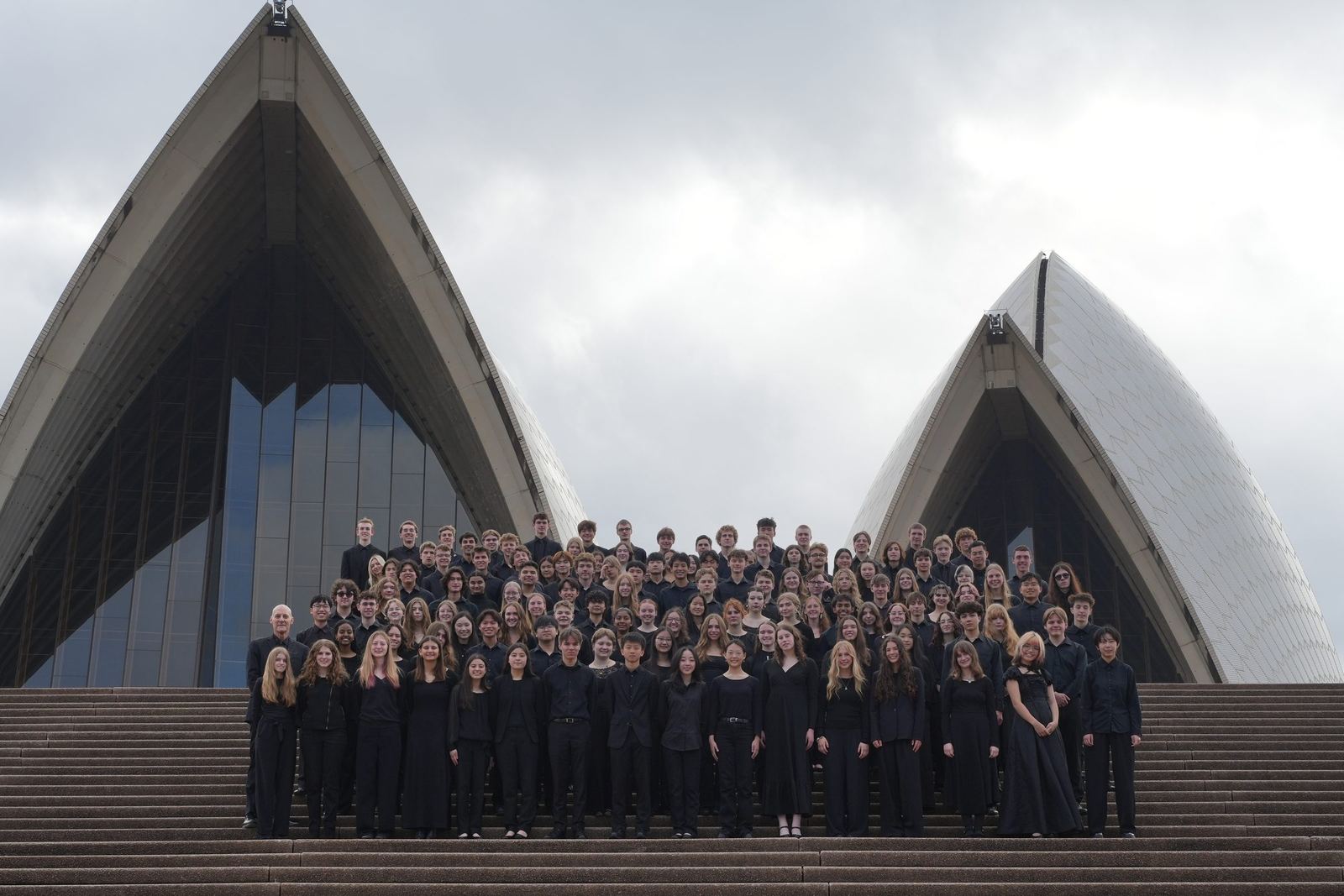 The ensemble on the Opera House steps between the sails