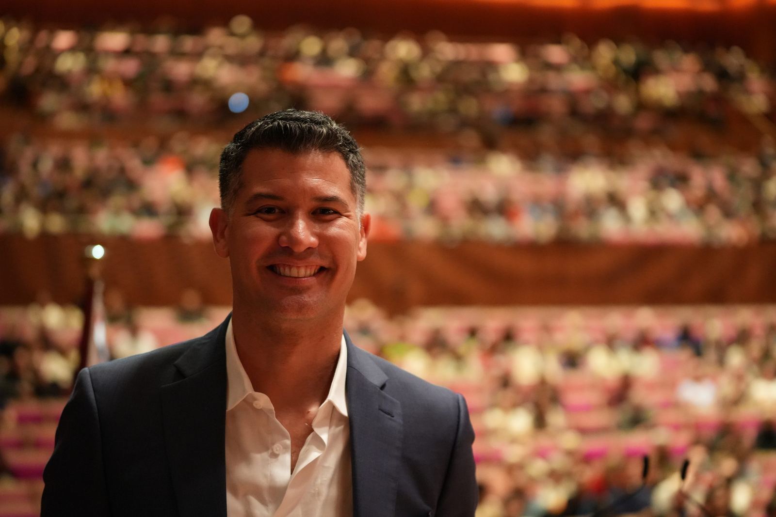 Guest smiling in front of a full Concert Hall audience